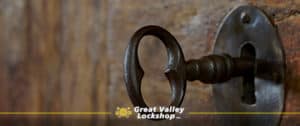 Antique skeleton key inside keyhole of an old wooden door.