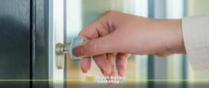 A homeowner locks the front door of a house.