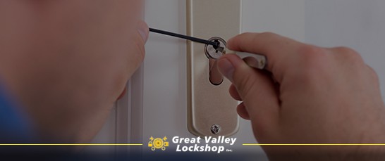 A locksmith uses picking tools to open a lock.