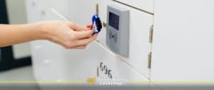 A woman holds a rfid bracelet to a locker in order to unlock it.